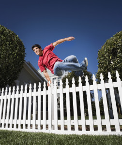 Hispanic man jumping over fence