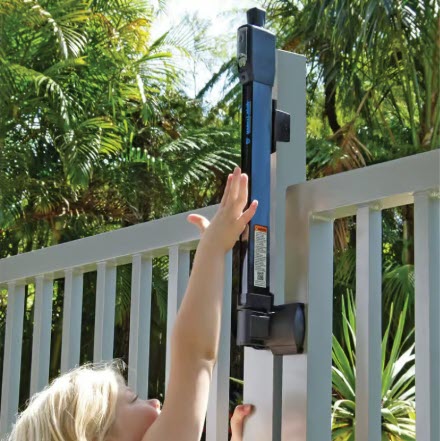 Child reaching up to open a BOCA-compliant MagnaLatch Top Pull safety latch on an aluminum pool fence – designed for secure child protection